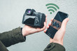 © stivog - Transferring photos from digital camera to his phone using wifi connection