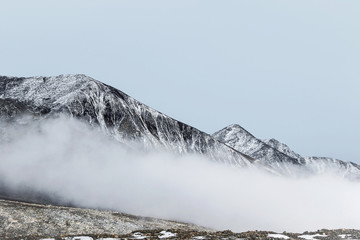 winter landscape of snow mountain peak in fog 