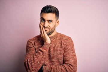 Sticker - Young handsome man wearing casual sweater standing over isolated pink background thinking looking tired and bored with depression problems with crossed arms.