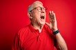 © Krakenimages.com - Grey haired senior man wearing glasses and casual t-shirt over red background shouting and screaming loud to side with hand on mouth. Communication concept.