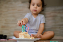Close Up Of Little Girl Kid Putting Some Candles In A Piece Of Cake