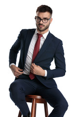 Wall Mural - formal man sitting and fixing jacket with style