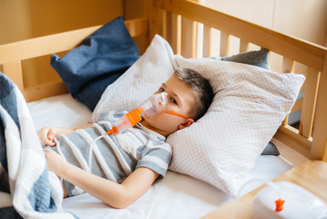 A young boy is given an inhalation during a lung disease. Medicine and care