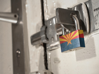 A bolted door secured by a padlock with the national flag of Arizona on it.(series)