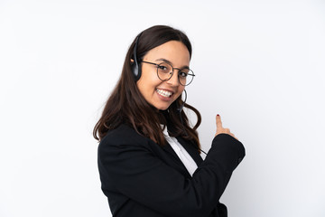 Young telemarketer woman isolated on white background pointing back