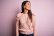 © Krakenimages.com - Young beautiful brunette woman wearing casual sweater over isolated pink background looking away to side with smile on face, natural expression. Laughing confident.