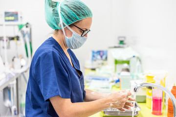 Coronavirus prevention. Nurse washing her hands after treat a patient with Covid-19 infection. Medical sanitizing procedure .