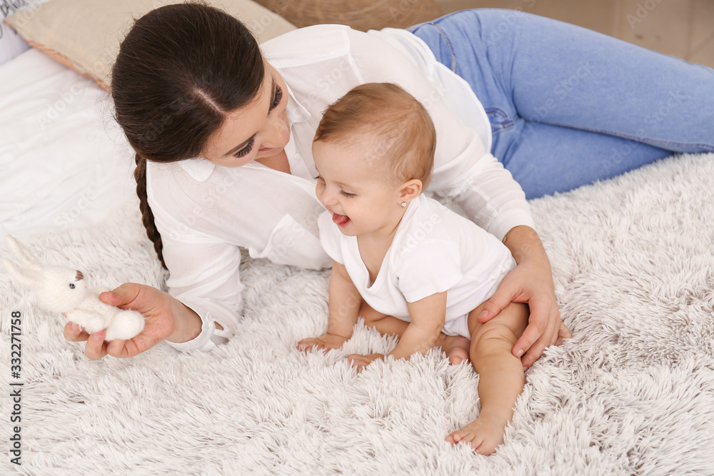 Happy mother with cute little baby at home