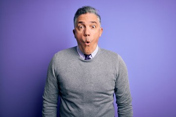 Sticker - Middle age handsome grey-haired man wearing elegant sweater over purple background afraid and shocked with surprise expression, fear and excited face.