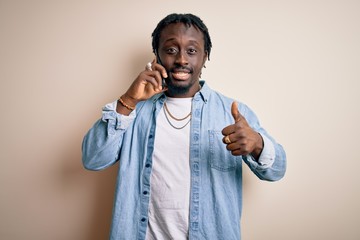 Sticker - African american man having conversation talking on the smartphone over white background happy with big smile doing ok sign, thumb up with fingers, excellent sign