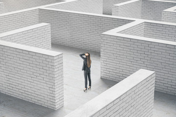 Aufkleber - Businesswoman standing in middle of a brick maze.