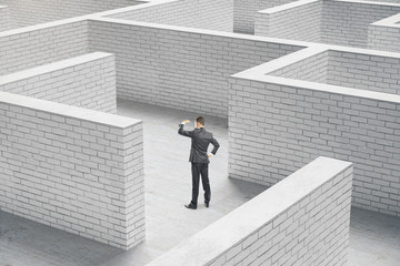Poster - Young businessman standing in brick maze.