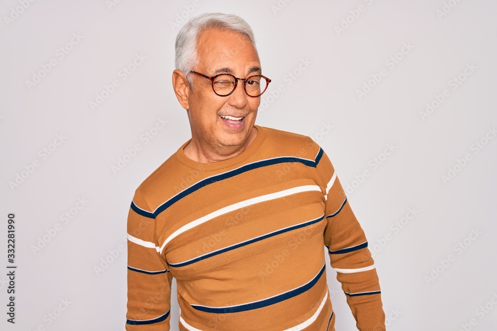 Middle age senior grey-haired handsome man wearing glasses and casual striped sweater winking looking at the camera with sexy expression, cheerful and happy face.