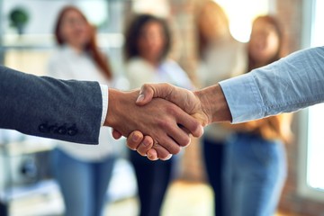 Group of business workers standing together shaking hands at the office