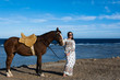 Piękna dziewczyna z koniem na plaży