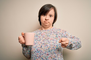 Sticker - Young down syndrome woman drinking a cup of hot coffee over isolated background annoyed and frustrated shouting with anger, crazy and yelling with raised hand, anger concept