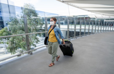 Wall Mural - Traveler with face mask affected by coronavirus travel ban and COVID-19 pandemic flight restrictions