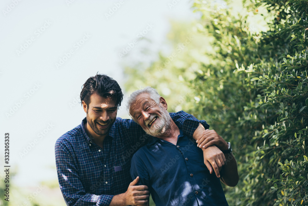 An adult hipster son and old senior father stay for work at home, two generations have a beard talking together and relaxing with smile, happy and enjoy living to isolation quarantine at home	 - obrazy, fototapety, plakaty 
