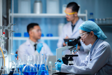 Wall Mural - young scientist looking through a microscope in a laboratory. young scientist doing some research.