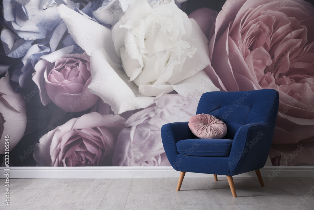 Comfortable armchair near wall with floral wallpaper, space for text. Stylish living room interior - obrazy, fototapety, plakaty 