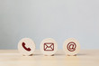 Wooden coins with symbol telephone, email, address. Website page contact us or e-mail marketing concept