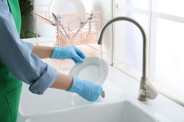 Canvas Print - Woman washing plate in modern kitchen, closeup