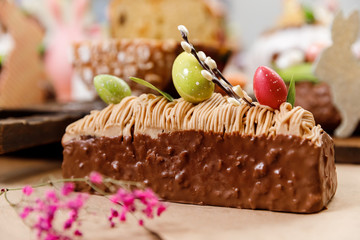 Wall Mural - Easter cake orthodox sweet bread kulich and colorful chocolate eggs on festive table