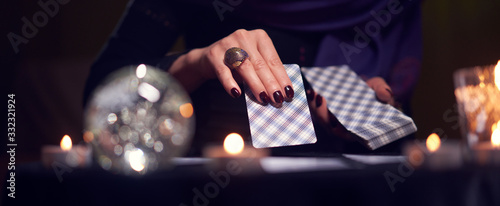 Fotomural Close-up of fortuneteller's hands with cards at table with candles, magic ball i