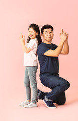 Wall Mural - Happy Asian man and his little daughter on color background