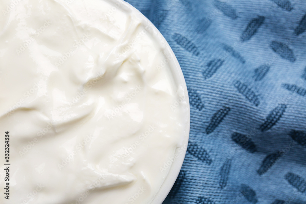 Bowl with tasty sour cream on table, closeup
