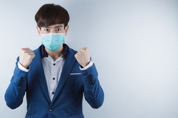 Wall Mural - The business man wearing mask for protecting coronavirus and pm 2.5 and show his hand to fight them. Coronavirus and Air pollution pm 2.5 concept.