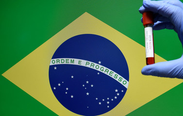 Corona virus or Covid-19 in Brazil , sample blood tube in hand with Brazil flag on background