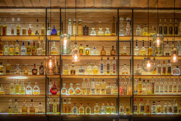 Defocused background of bar counter with various bottles of alcohol.