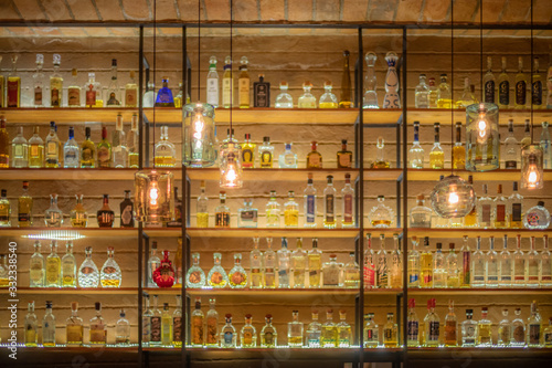 Fotografía Defocused background of bar counter with various bottles of alcohol