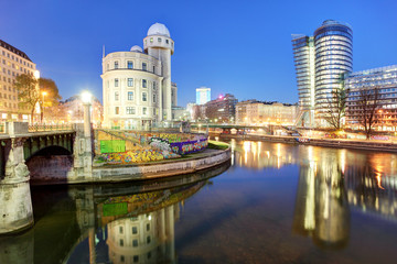 Wall Mural - Danube Canal of Vienna, Austria. At the right the new UNIQA-Tower and opposite the historic building Urania.