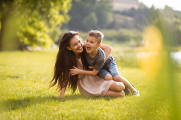 Playful mother in park holding her son