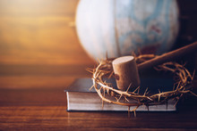 Close Up Of Crown Of Thorns Of Jesus And Wooden Hammer Look Like Judge Gavel On  Bible Over Blurred World Globe  On Wooden Table. Christian Background Show God Justice And Christ's Redemption  Concept