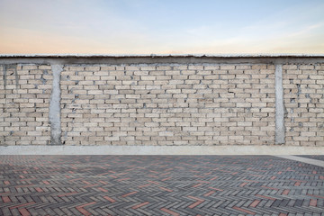 Wall Mural - Gray brick wall with empty brick pavement