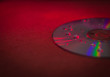 CD disk with droplets of water in red light close-up