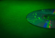 CD disk with droplets of water in green light close-up