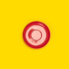 Wall Mural - Top view of red ceramic plate saucer on yellow background