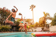 © Alessandro Biascioli - Group happy friends jumping in pool at sunset time - Crazy young people having fun making party in exclusive tropical house - Summer holidays vacation and youth culture lifestyle concept