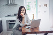 © Suntipong - Portrait of beautiful young latin woman talking over the phone while cooking in kitchen
