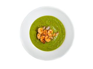 A plate of thick fresh green pea soup with prawns isolated on white. Top view.