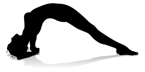 A silhouette of a woman in a yoga or pilates pose