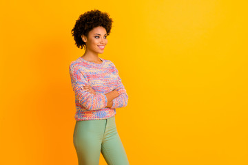 Wall Mural - Portrait of cheerful lovely afro american girl cross hands look copy space listen her friend enjoy autumn holiday wear green pants isolated over shine color background