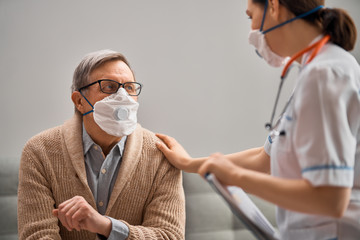 Doctor and senior man wearing facemasks