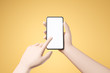 © Foxstudio - Cartoon hand holding smartphone with blank white screen and push the screen over yellow background.