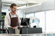Startup of small business owner, Successful SME. Confident Male Barista working on counter at the coffee shop. Portrait of Happy smiling Bearded man wear white shirt and brown apron making coffee