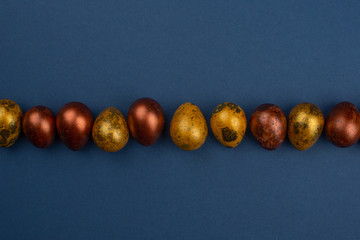 Wall Mural - Golden easter eggs on blue